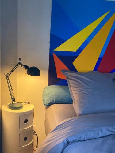 um quarto com uma cama e um candeeiro numa mesa de cabeceira em King size lounge 76m2 de confort au centre ville em Mulhouse