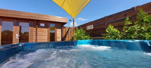 a large plunge pool in a backyard with a yellow umbrella at Corden Village in Łeba