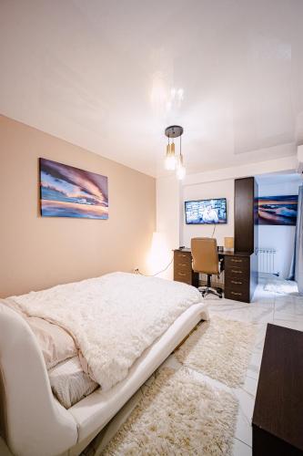 a bedroom with a large white bed and a desk at Seaside Blues Apartment Located in 5 Star Resort in Năvodari