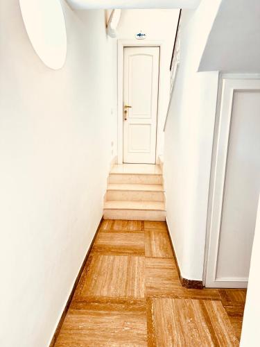 a hallway with a white door and wooden floors at Villa La Zagara by CapriRooms in Capri