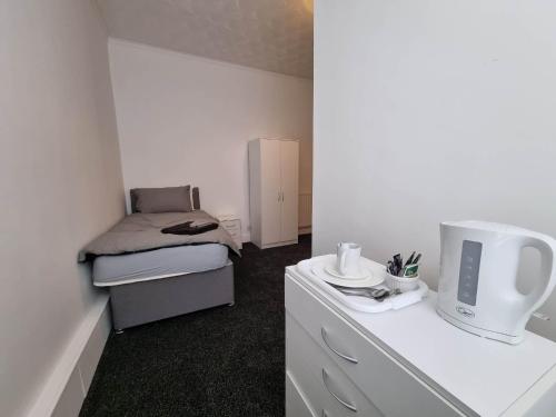 a small room with a bed and a white dresser at 70 Southfield in Middlesbrough