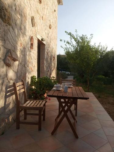 een houten tafel en 2 stoelen op een patio bij Olive Trees in Tragaki