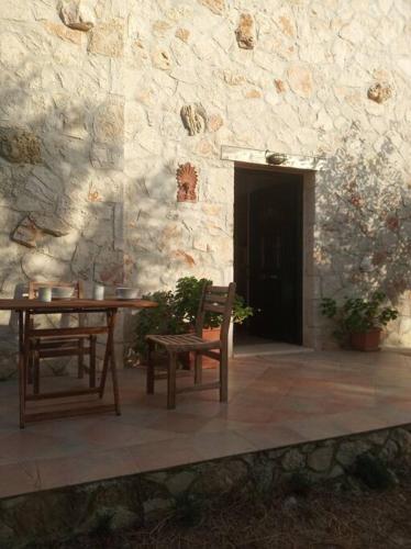 a table and chairs in front of a stone building at Olive Trees in Tragaki