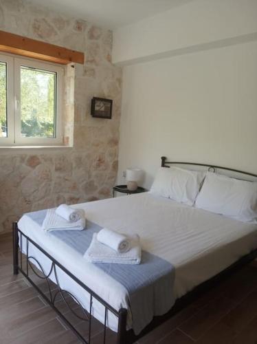 a bedroom with a large bed with towels on it at Olive Trees in Tragaki