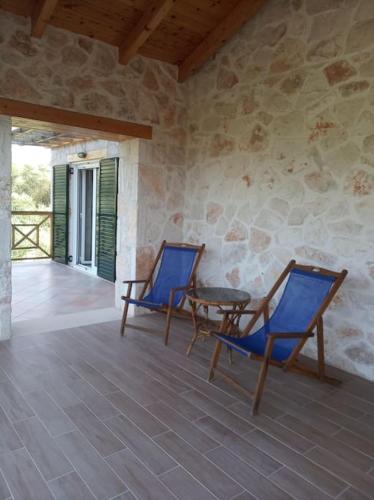 two blue chairs and a table on a patio at Olive Trees in Tragaki
