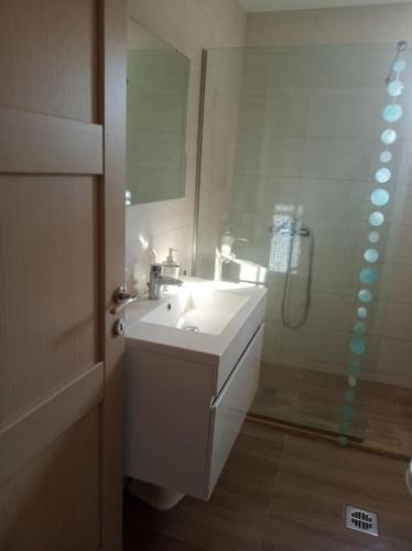 a bathroom with a white sink and a shower at Olive Trees in Tragaki