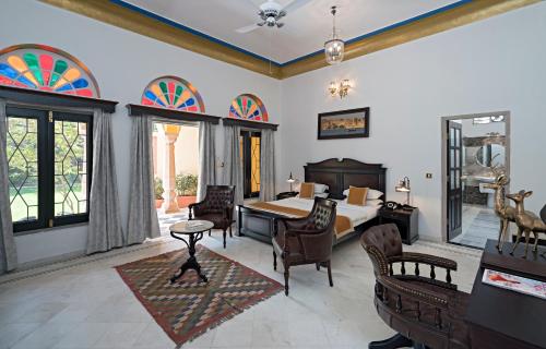 1 dormitorio con 1 cama, mesa y sillas en Hotel Narain Niwas Palace, en Jaipur