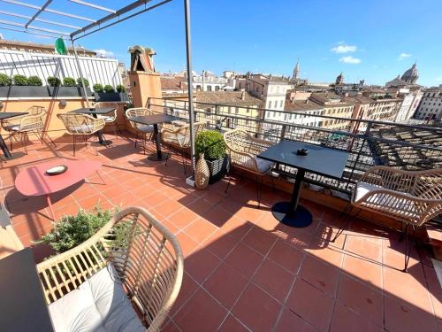 a patio with tables and chairs on a roof at Navona 49 Luxury Suites&Apartment in Rome