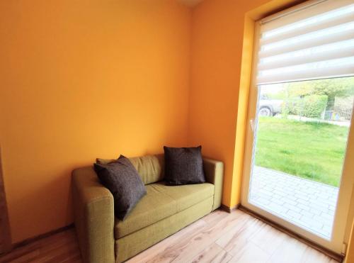 a living room with a couch and a large window at Yellow Apartment in Wieliczka