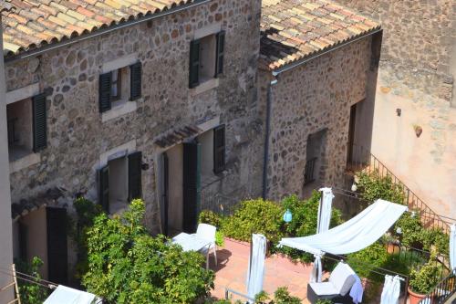 an external view of a building with white tables and chairs at Hotel Nord Boutique in Estellencs