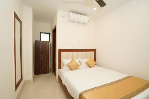 a bedroom with a large white bed with yellow pillows at Hotel Royal Palace in Guwahati