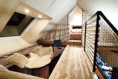 a living room with a staircase and a couch at Maison Aux portes d'Emparis in Mizoën