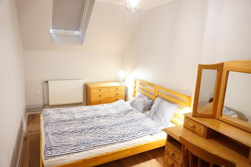 ein Schlafzimmer mit einem Bett, einer Kommode und einem Spiegel in der Unterkunft Insko Home & Sauna in Ińsko