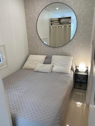 une chambre avec un lit avec un miroir au mur dans l'établissement Joli Studio proche plage, au Cap d'Agde