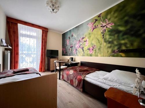 a bedroom with a bed and a painting on the wall at Sanatorium Energetyk in Krynica Zdrój