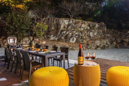 a table with a bottle of wine and some chairs at Sayuragi Villa 白浜 in Shirahama