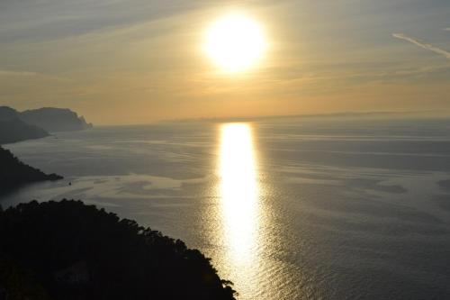 a sunset over the ocean with the sun in the sky at Hotel Nord Boutique in Estellencs
