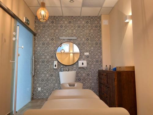 a bathroom with four beds and a mirror at Sanatorium Energetyk in Krynica Zdrój