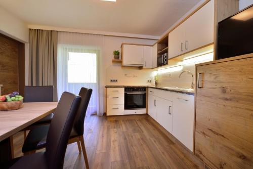 a kitchen with a table and a dining room at Aparthotel Garni Monte in Kartitsch