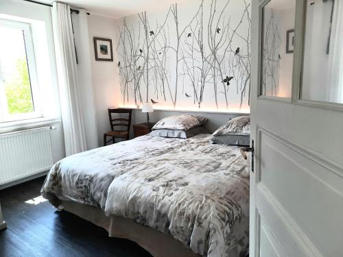 a bedroom with a bed with a comforter on it at Maison d'hôtes La Renardière in Reichshoffen