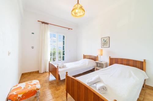 una camera da letto con due letti e una finestra di Villa Prima a Kato Korakiana