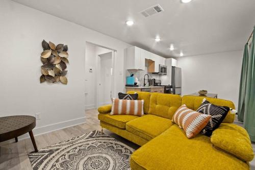 uma sala de estar com um sofá amarelo e uma cozinha em "A Home 4 All" X Lots of Goodies X Free Parking em Dallas