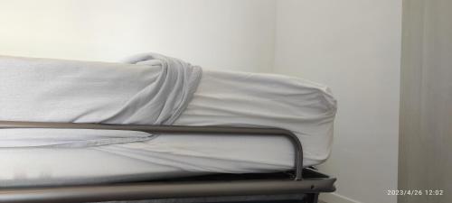 a bed with white sheets and a pillow at Appartamenti a Bardolino in Bardolino