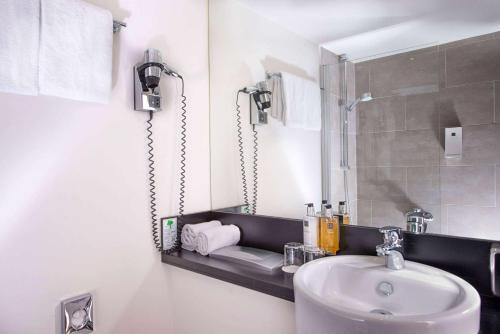 a bathroom with a sink and a mirror at Wyndham Stuttgart Airport Messe in Stuttgart