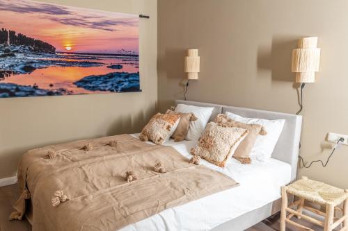 a bed in a bedroom with a painting on the wall at Hotel Restaurant Toxopeus in Anjum
