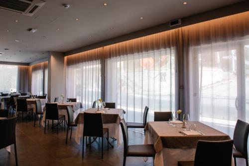 a restaurant with tables and chairs and large windows at Hotel Principe d'Aragona, Sure Hotel Collection by BW in Modica