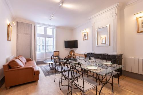 un salon avec une table et un canapé dans l'établissement Les Joyaux Tournusiens, à Tournus