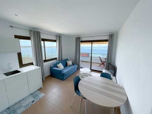 拉薩維納的住宿－Turquesa & Ambar Apartments Formentera，客厅配有桌子和蓝色沙发