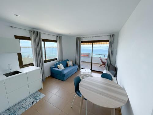 ein Wohnzimmer mit einem Tisch und einem blauen Sofa in der Unterkunft Turquesa & Ambar Apartments Formentera in La Savina