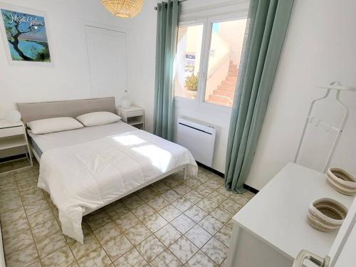 een witte slaapkamer met een bed en een raam bij Appartement Six-Fours-les-Plages, 3 pièces, 5 personnes - FR-1-316-316 in Six-Fours-les-Plages