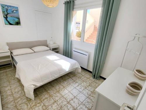 une chambre blanche avec un lit et une fenêtre dans l'établissement T3 climatisé avec Wi-Fi et parking privé - À 200 m de la plage - FR-1-316-316, à Six-Fours-les-Plages