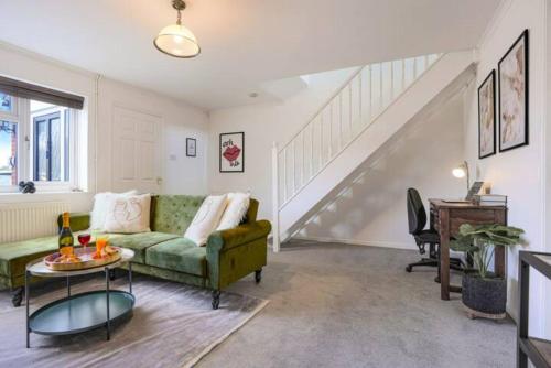 sala de estar con sofá verde y escaleras en Blandford House with Free Parking, Fast Wifi, Smart TV with Netflix and Private Garden by Yoko Property en Coventry