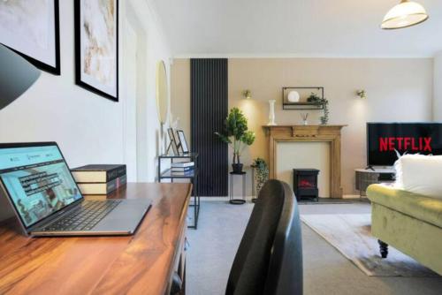 a living room with a laptop on a wooden desk at Blandford House with Free Parking, Fast Wifi, Smart TV with Netflix and Private Garden by Yoko Property in Coventry