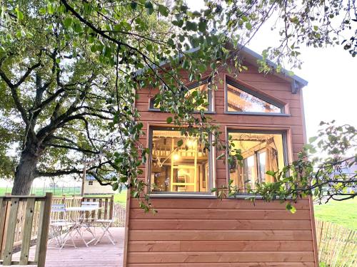a tiny house with a large window on a deck at Gites De L'Etang Des Noues in Cholet