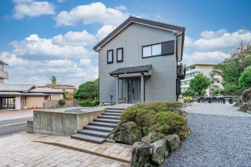 a house with a staircase in front of it at Sayuragi Villa 白浜 in Shirahama