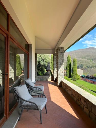 une terrasse avec des chaises et une cheminée dans une maison dans l'établissement Villa Belvedere di Popiglio, à Popiglio