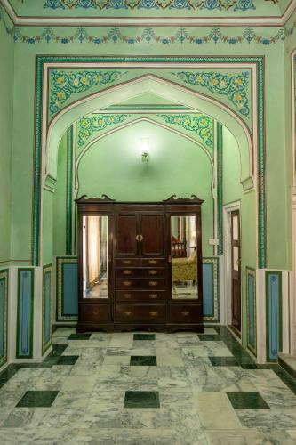 a room with an archway with a wooden cabinet in it at Hotel Narain Niwas Palace in Jaipur