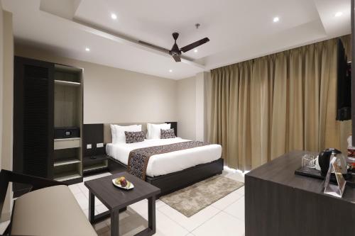 a hotel room with a bed and a couch at Pride Biznotel Canopus, Digha in Digha