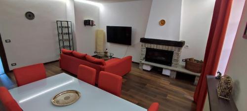 a living room with a red couch and a fireplace at La Terrazza sul Borgo in Mombaldone