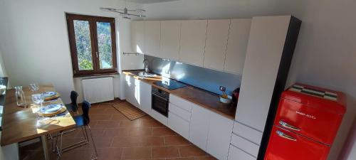 a kitchen with white cabinets and a red refrigerator at La Terrazza sul Borgo in Mombaldone