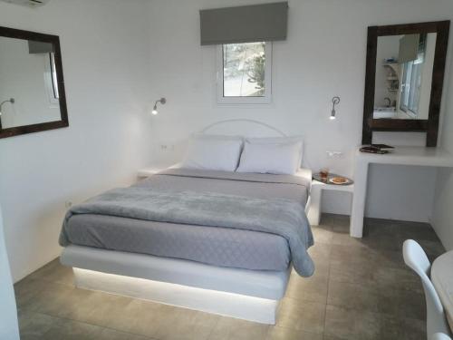 a bedroom with a bed and a table and a mirror at Filia Bungalow in Archangelos