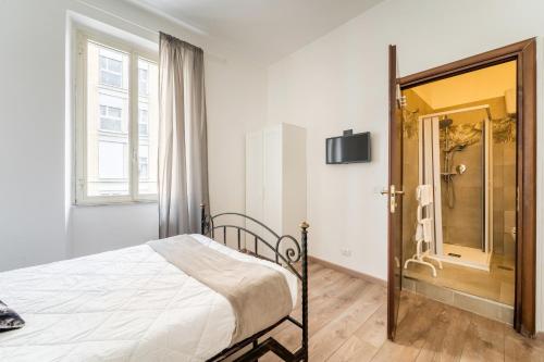 a bedroom with a bed and a walk in shower at Rooms Piramide in Rome