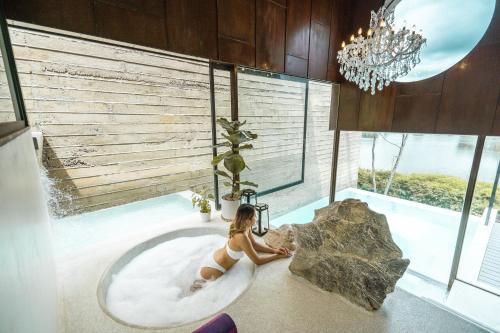 北碧的住宿－Fallingwater Pool Villa by Cross River Kwai，坐在浴室浴缸里的女人