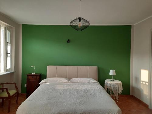 een slaapkamer met een groene muur en een bed bij Cà Trifolera Barbaresco - Appartamento per 2 o 4 persone immerso nei vigneti - Free Parking Wi-Fi - in Barbaresco
