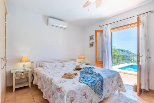 a bedroom with a bed and a balcony with a pool at Holiday Villa Near Denia in Adsubia