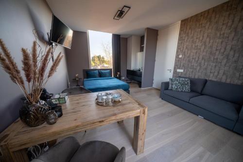 salon z niebieską kanapą i stołem w obiekcie Bed & Wellness Boxtel, luxe kamer met airco en eigen badkamer w mieście Boxtel